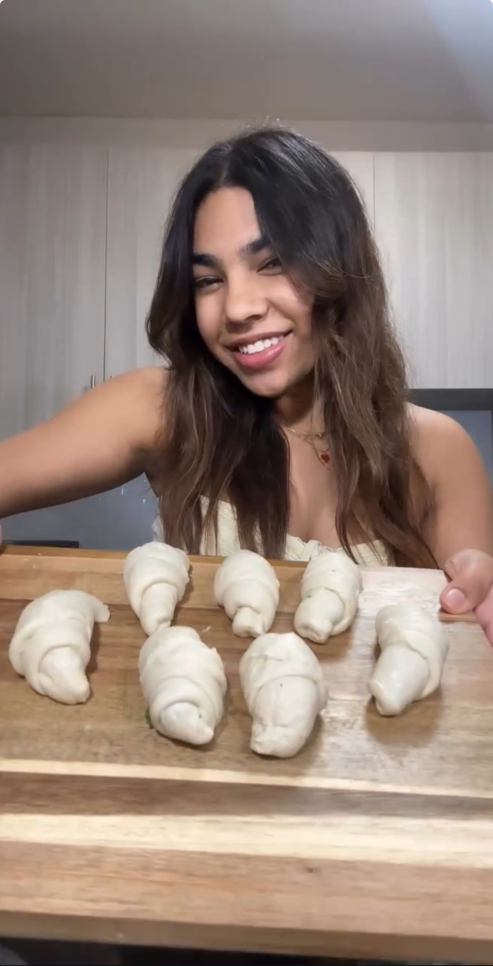 Tanisha smiling behind a board of hand-shaped croissants