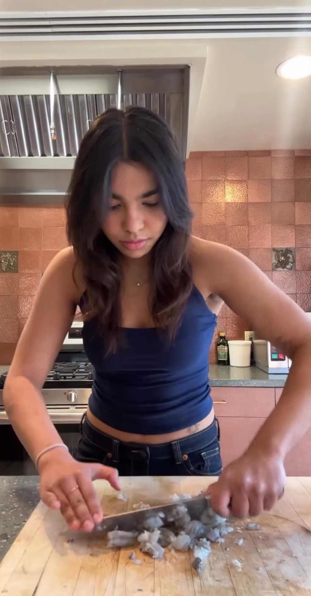 Tanisha working at the cutting board in a warm terracotta-tiled kitchen